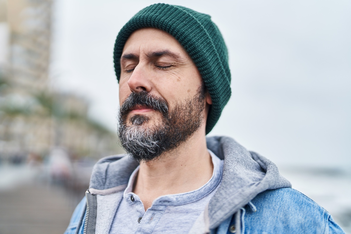 man breathing with closed eyes at seaside
