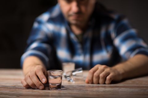 male alcoholic drinking shot at night